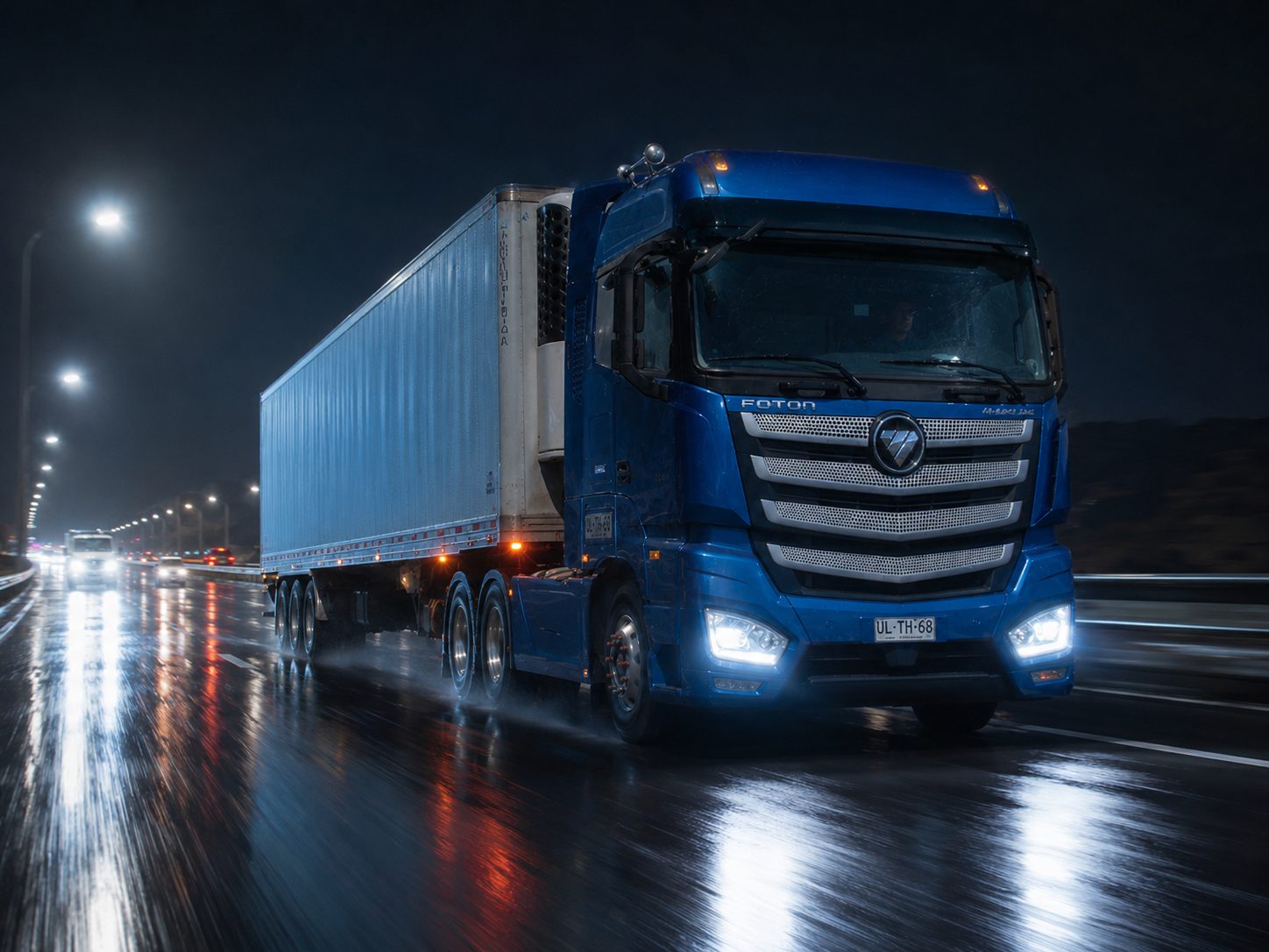 Camión Foton Auman en carretera de noche bajo lluvia, transporte de carga refrigerada